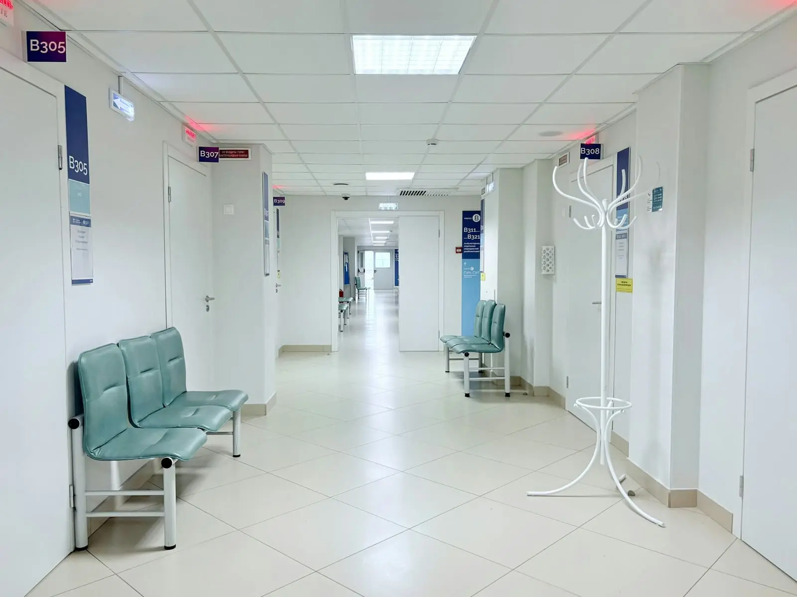 An empty hospital corridor with benches along the wall